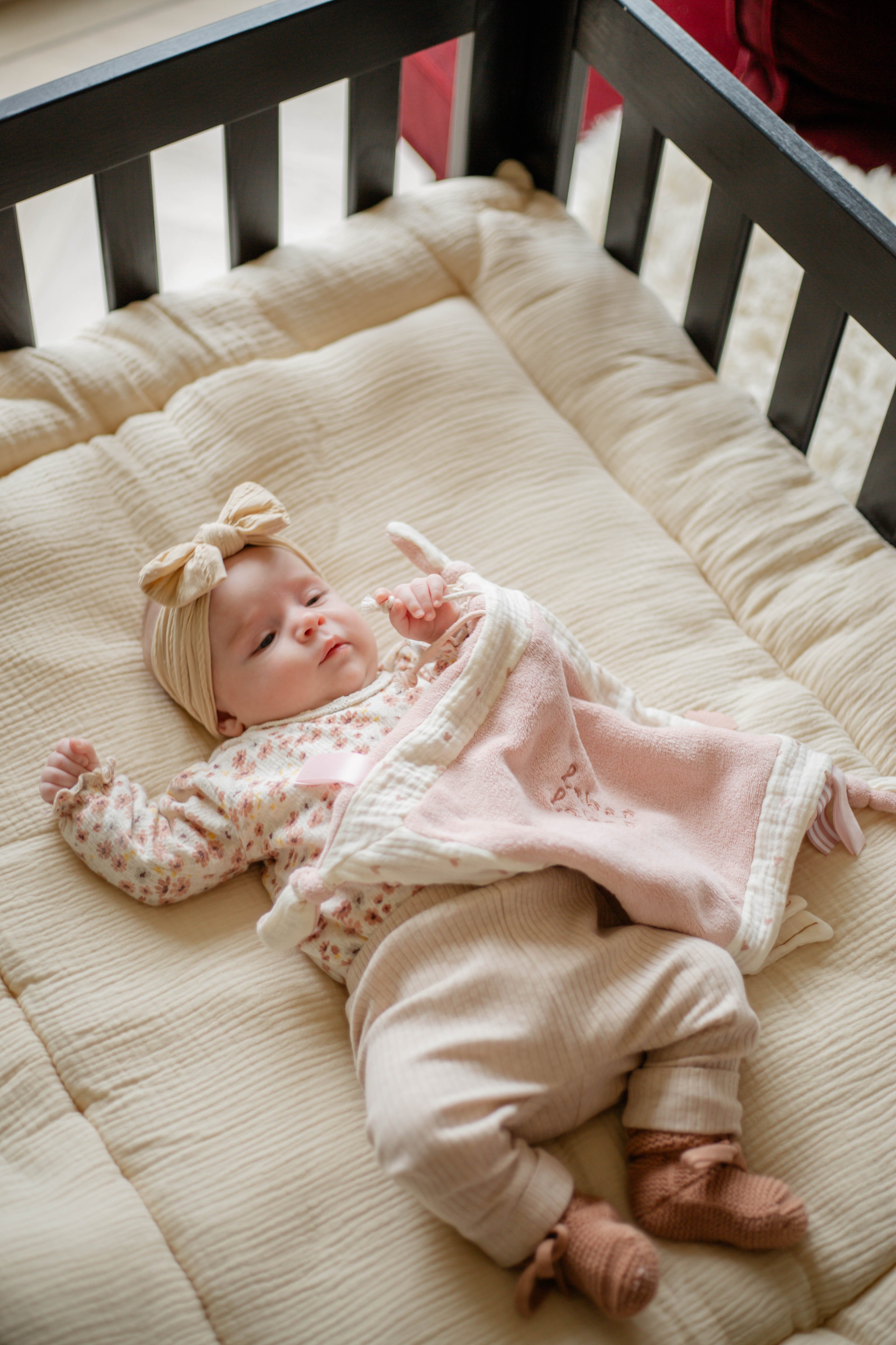 Doudou plat bébé en mousseline biologique doux et léger cœur rose avec bébé dans le parc