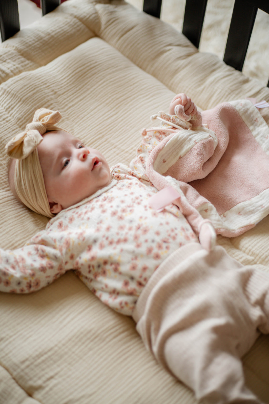 Doudou plat bébé en mousseline biologique doux et léger cœur rose avec bébé dans le lit