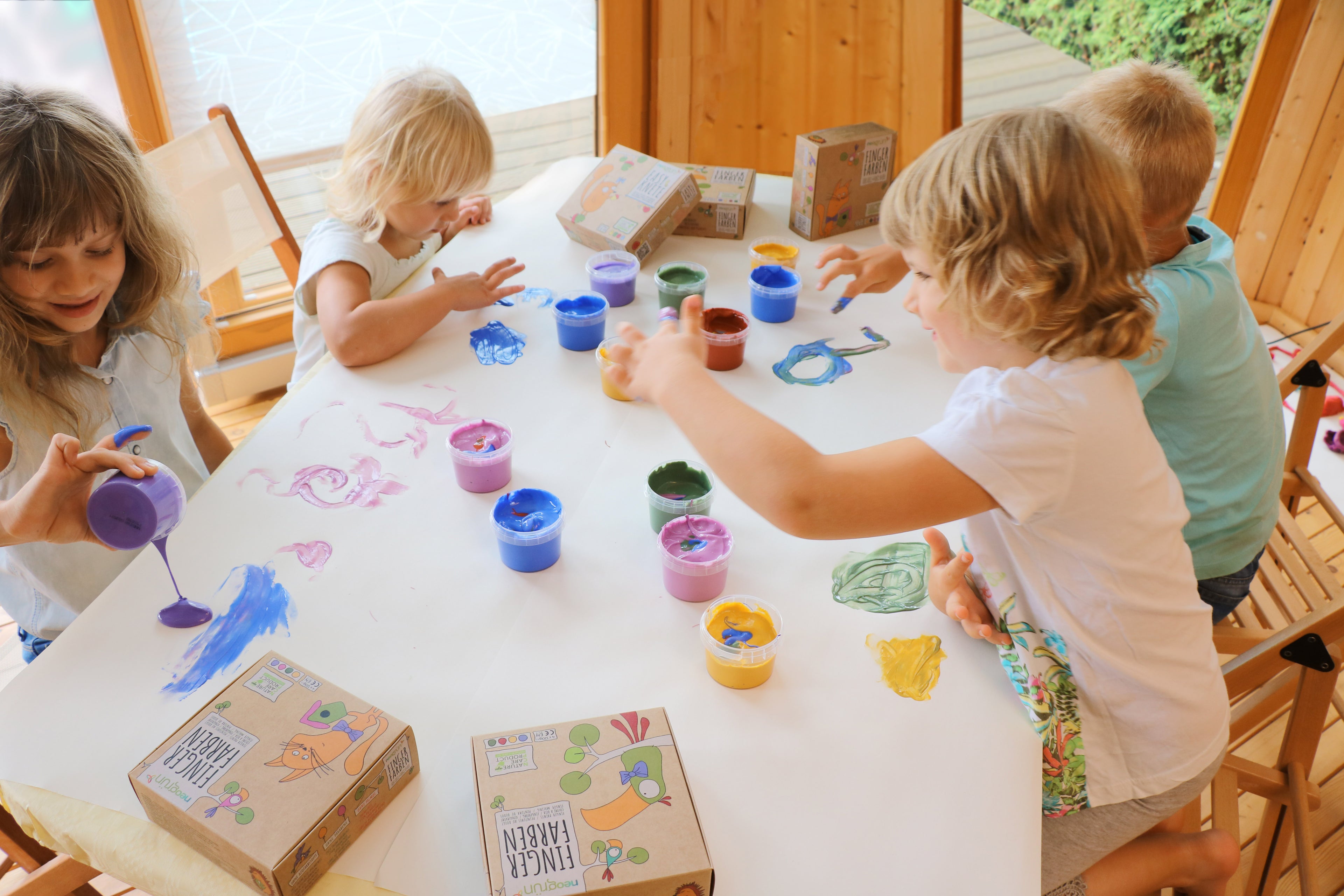 Groupe d'enfants qui joue avec le coffret créatif de peinture Aki 