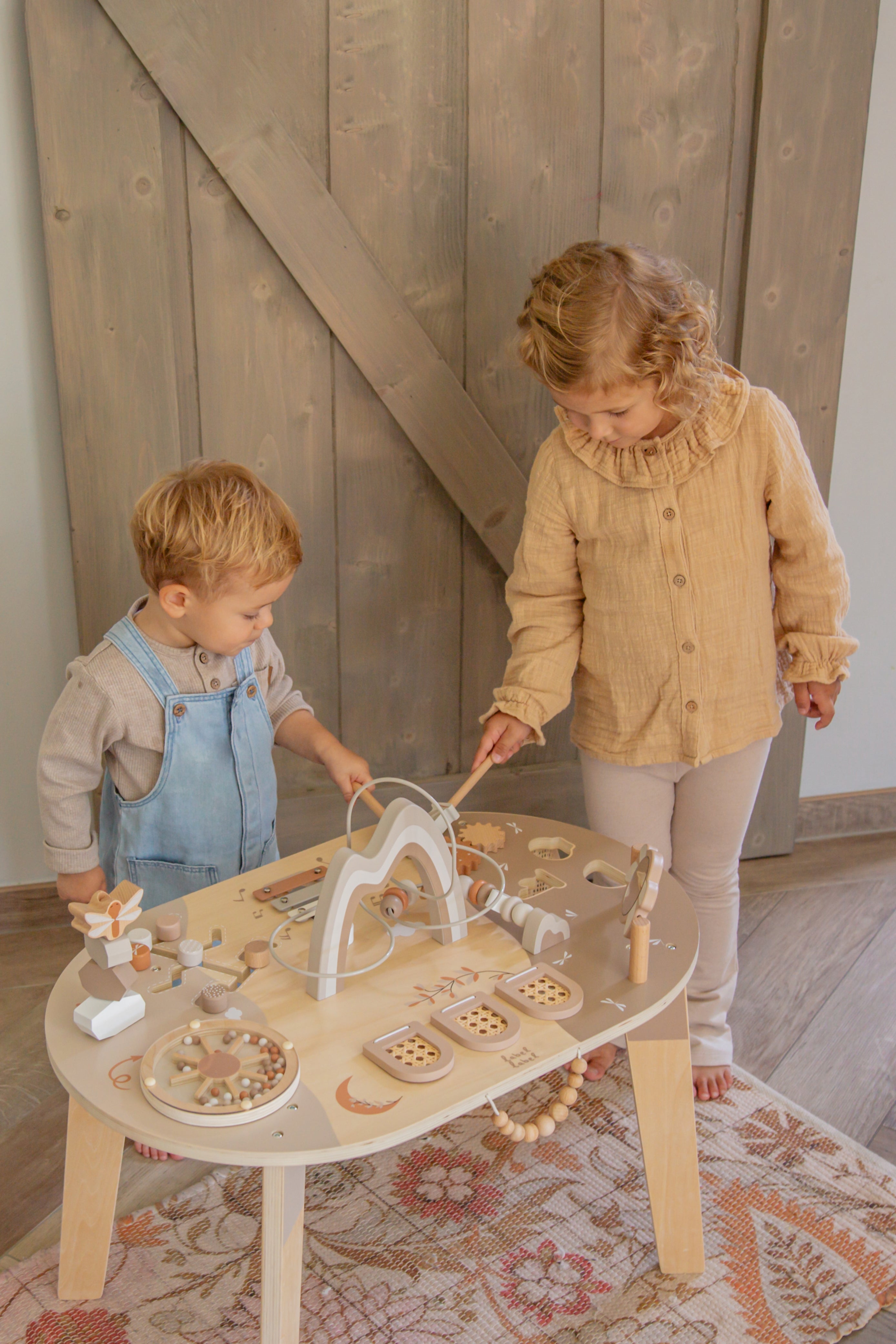 Deux enfants jouant avec la table d’activité enfant en bois avec jeux interactifs