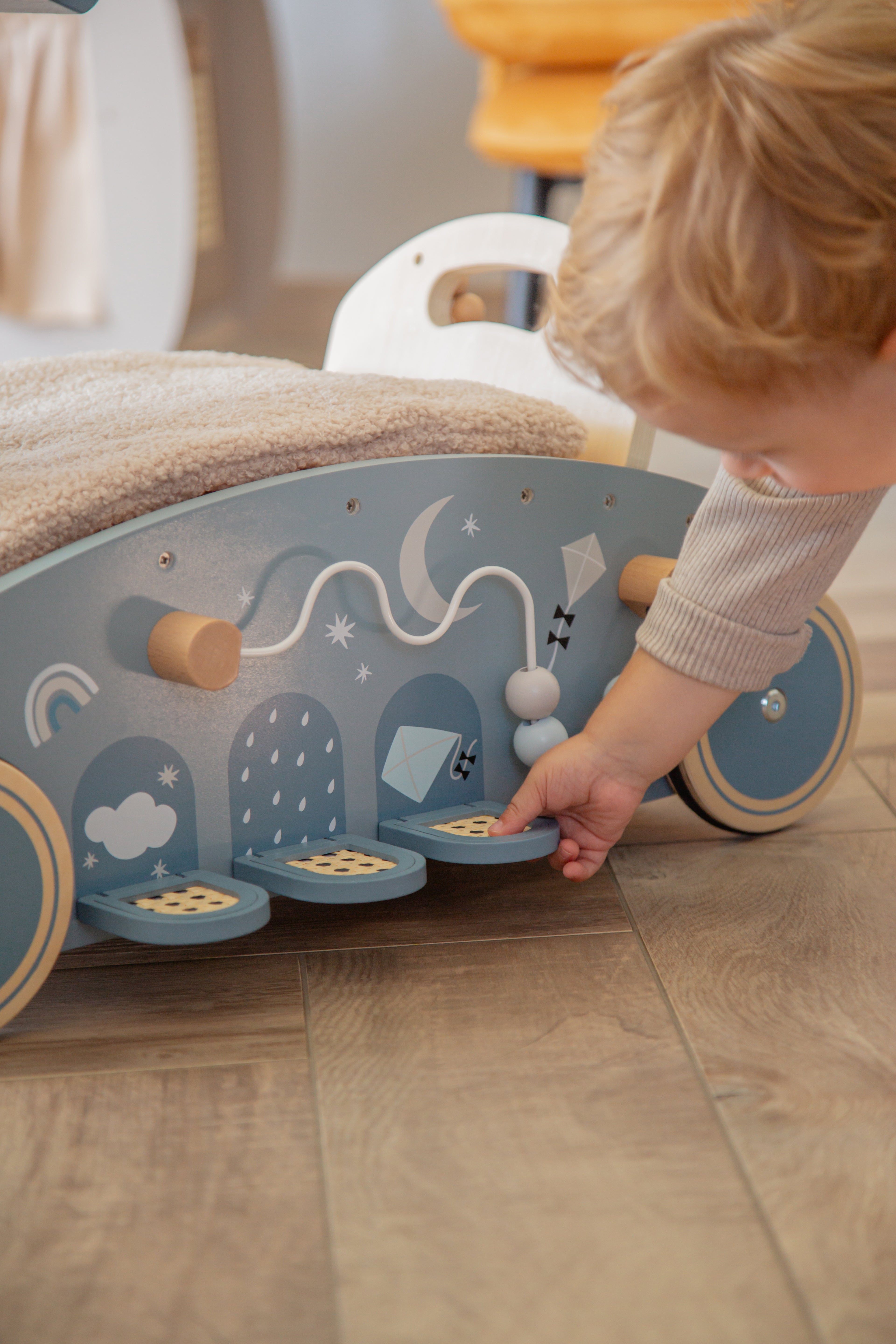 Voiture en bois 3 en 1 bébé marcheur bascule et porteur rose ou bleu vue latérale et petit garçon qui joue 
